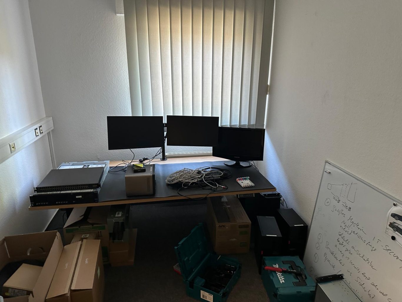 Nachher Bild Büroumzug Büro mit zwei Monitoren, einem Schreibtisch und Umzugskartons.