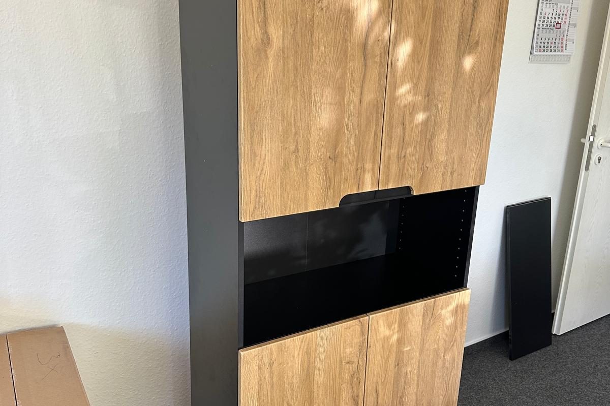 Schrank mit Holz- und schwarzen Akzenten in einem Raum gerade erst Zusammengebaut