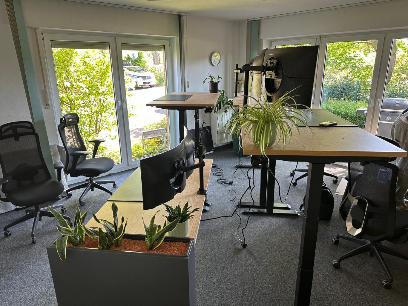Nachher Bild Büroumzug Modern Büro mit hoher und niedriger Arbeitsfläche, Pflanzen und Stühlen.